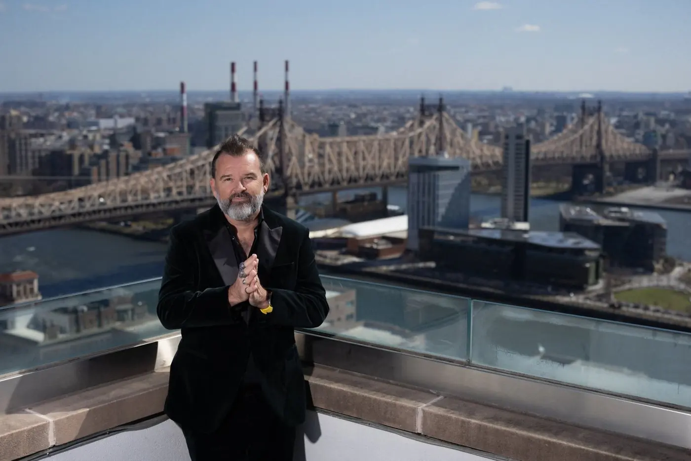 Philippe Cesson on a rooftop with a bridge and river behind him